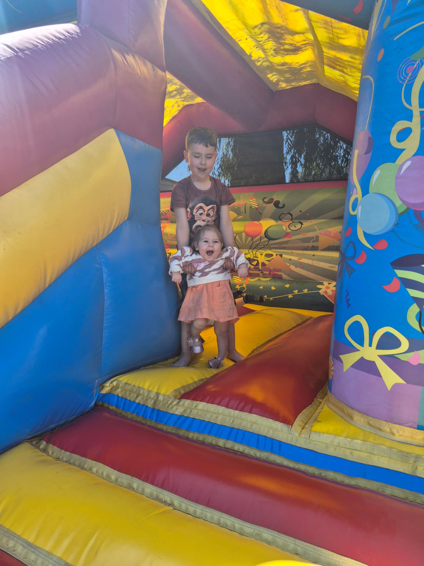 Kinderen springen op het springkasteel in den hof